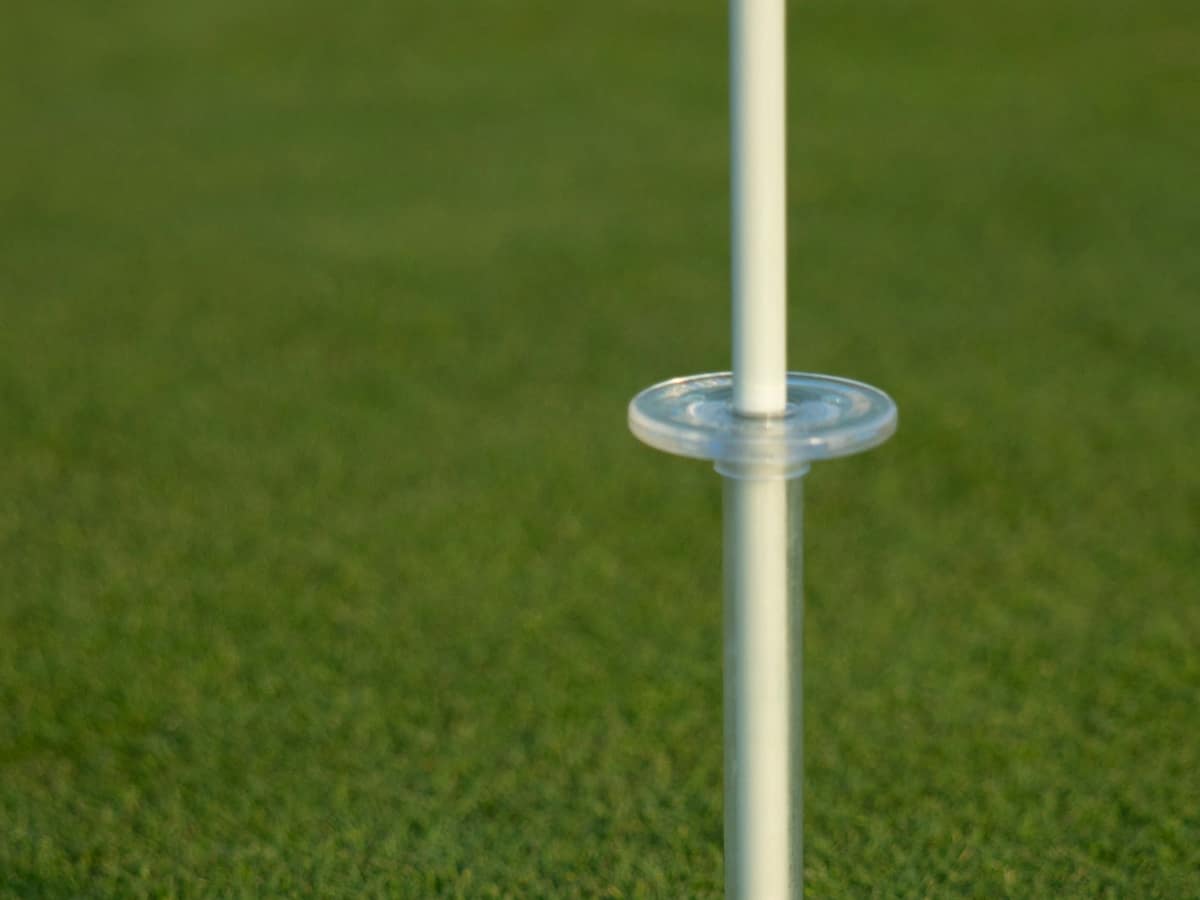 A flagstick standing in the hole on a green